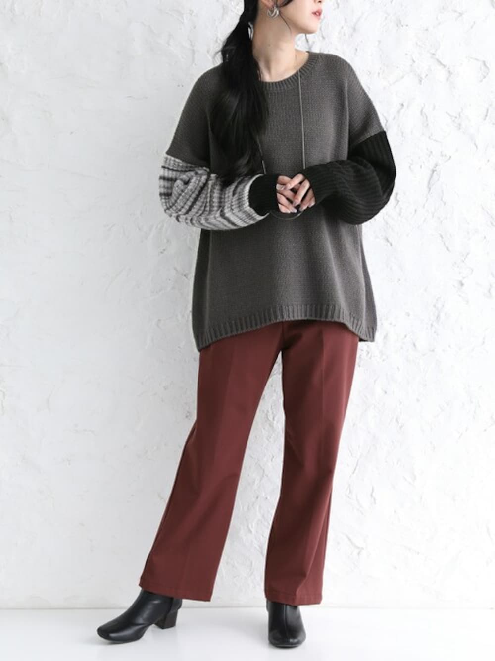 ブラウン系のその他パンツ、グレー系のニット/セーターを着用したレディースの冬コーディネートの1枚目の写真