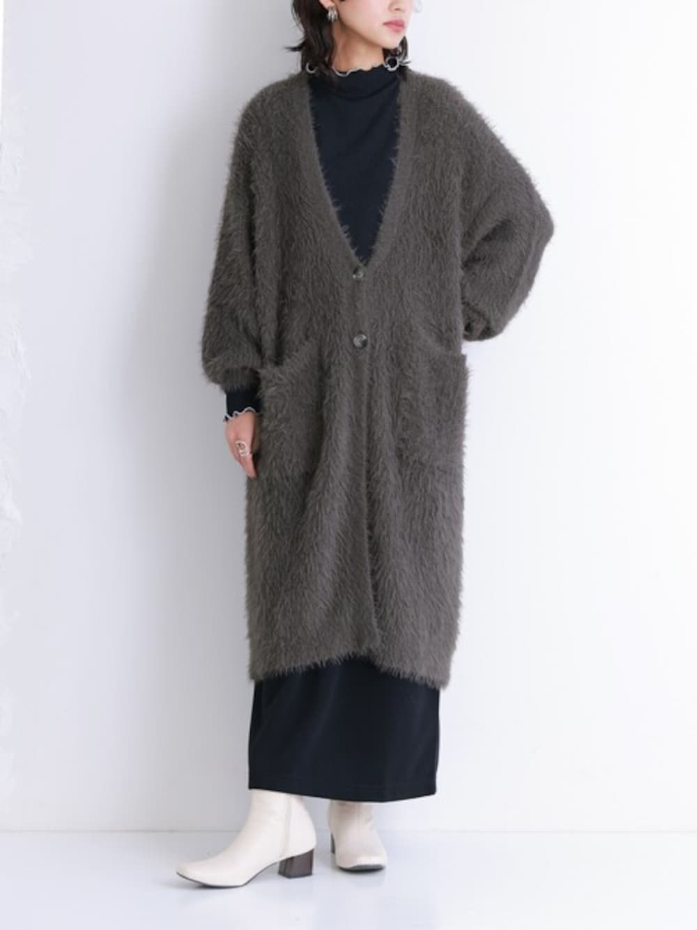 グレー系のカーディガン/ボレロ、ブラック系のTシャツ/カットソー、ブラック系のスカートを着用したレディースの冬コーディネートの1枚目の写真