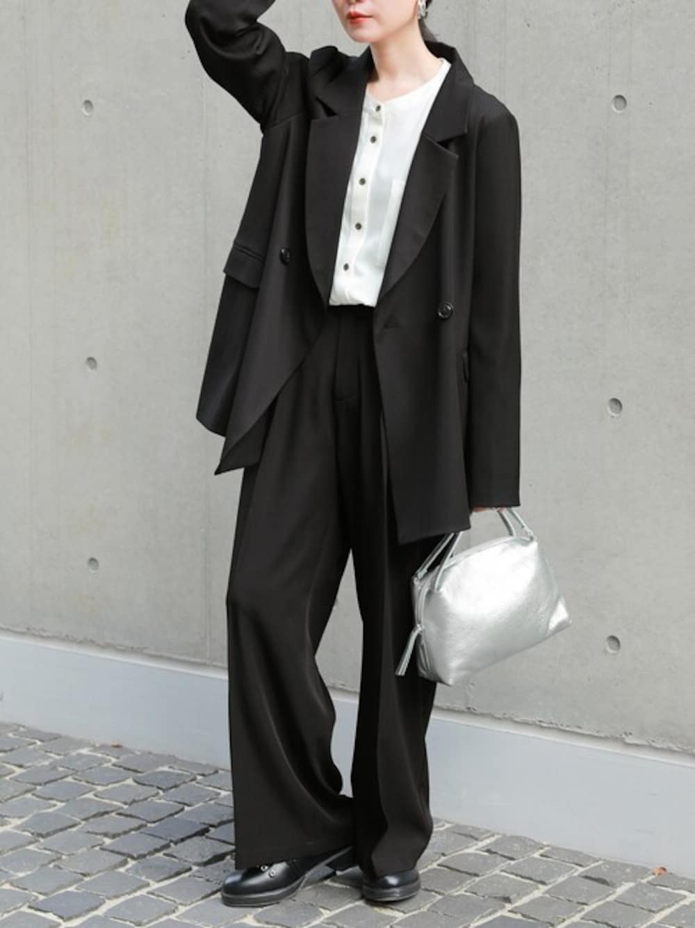 ブラック系のスラックス、ブラック系のテーラードジャケット、ホワイト系のシャツ/ブラウスを着用したレディースの冬コーディネートの1枚目の写真