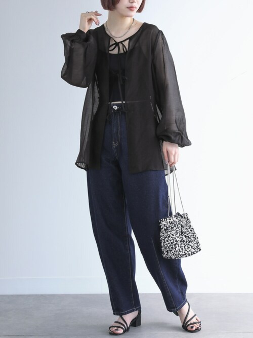 ブラック系のシャツ/ブラウス、ブルー系のデニムパンツを着用したレディースの冬コーディネートの1枚目の写真