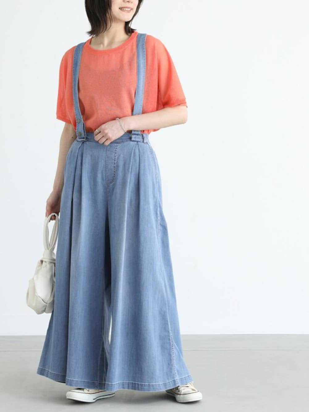オレンジ系のTシャツ/カットソー、ブルー系のデニムパンツを着用したレディースの夏コーディネートの1枚目の写真