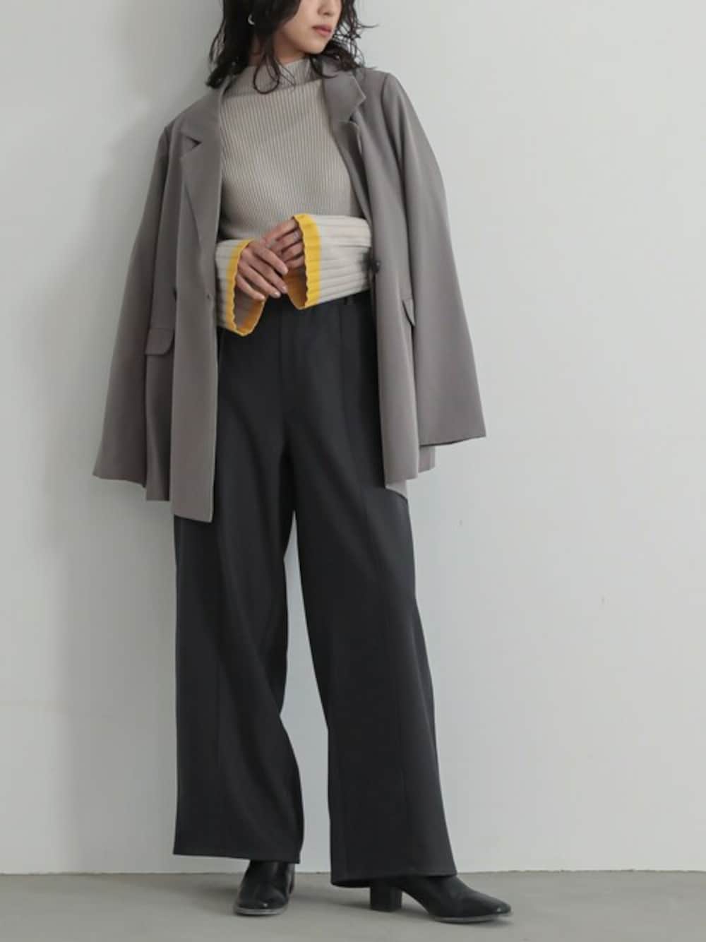 グレー系のスラックス、ベージュ系のニット/セーター、グレー系のテーラードジャケットを着用したレディースの冬コーディネートの1枚目の写真