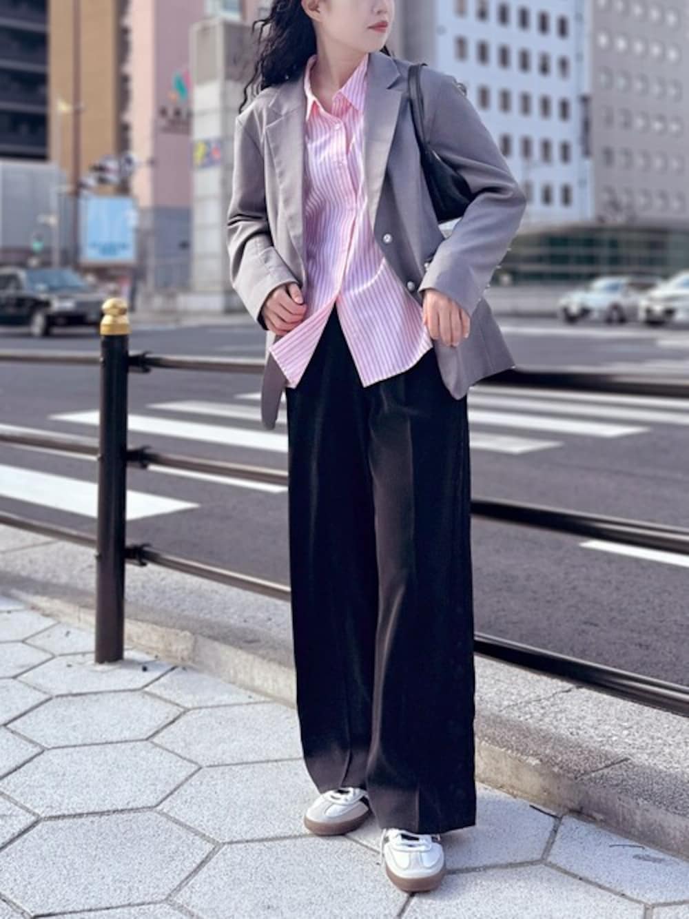 ピンク系のシャツ/ブラウス、ブラック系のスラックス、グレー系のテーラードジャケットを着用したレディースの春コーディネートの1枚目の写真