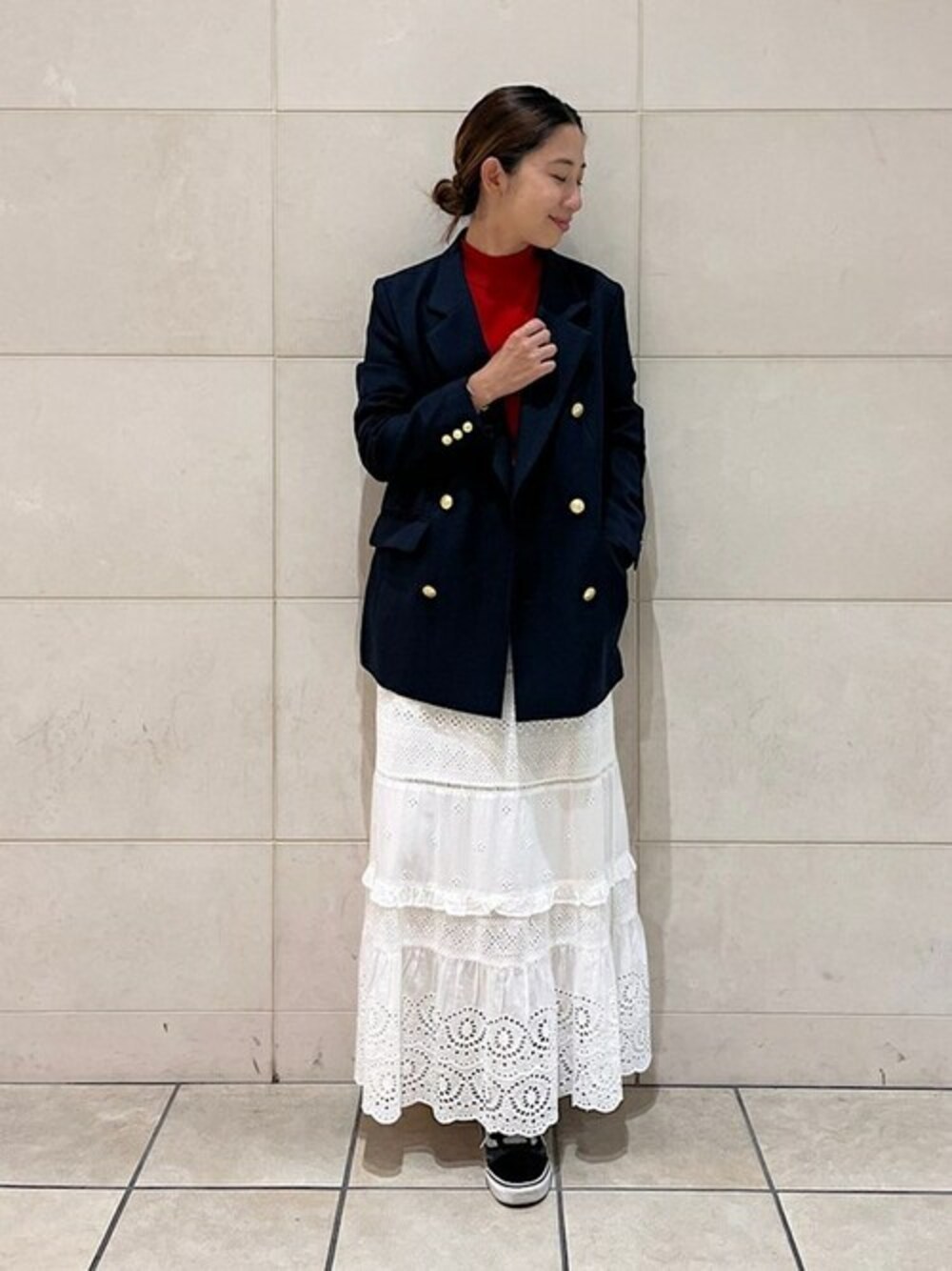 レッド系のニット/セーター、ブルー系のテーラードジャケット、ホワイト系のスカートを着用したレディースの秋コーディネートの1枚目の写真