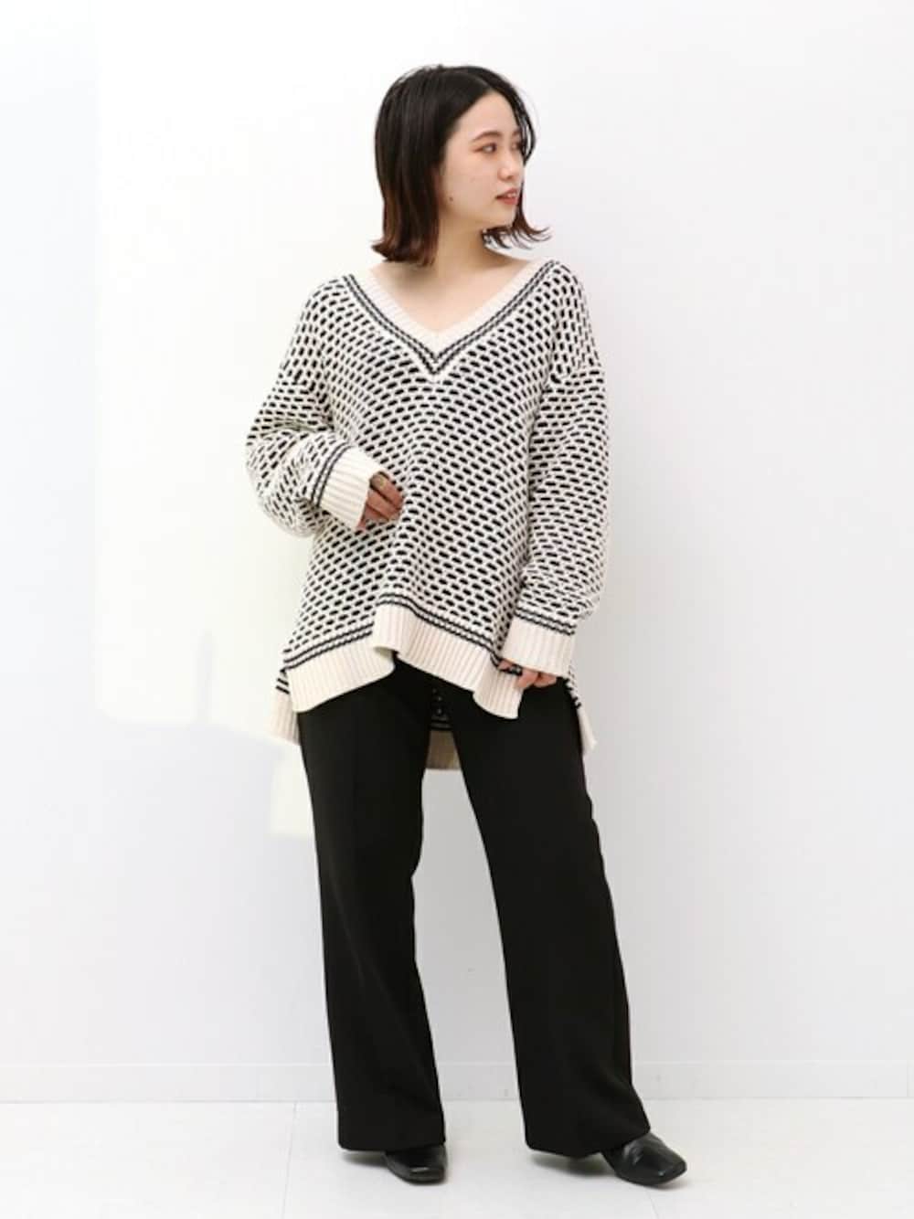 ベージュ系のニット/セーター、ブラック系のスラックスを着用したレディースの冬コーディネートの1枚目の写真