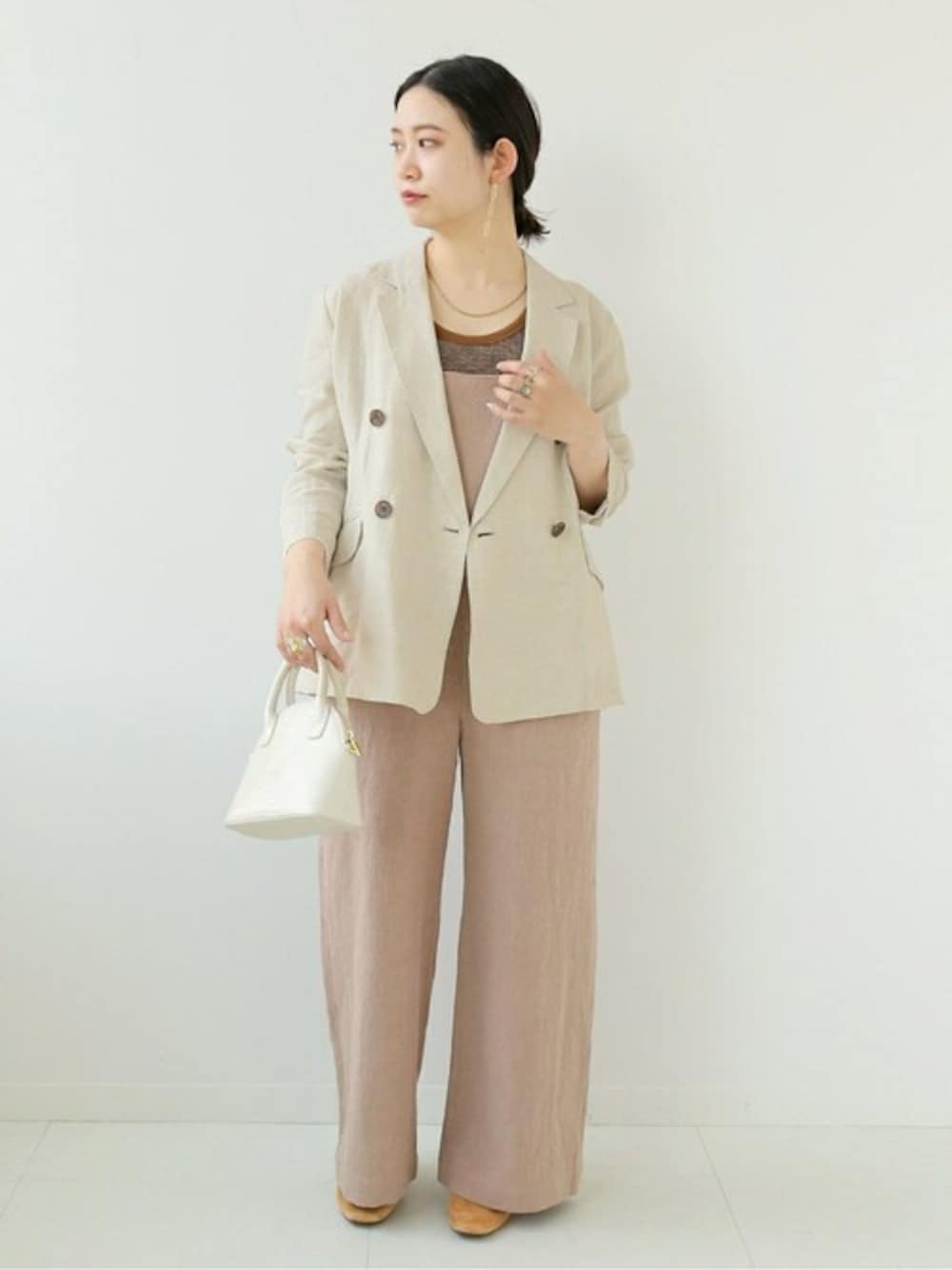 ベージュ系のテーラードジャケット、ピンク系のサロペット/オーバーオールを着用したレディースの春コーディネートの1枚目の写真