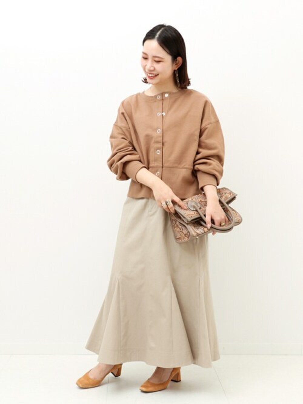 ブラウン系のTシャツ/カットソー、ベージュ系のスカートを着用したレディースの春コーディネートの1枚目の写真