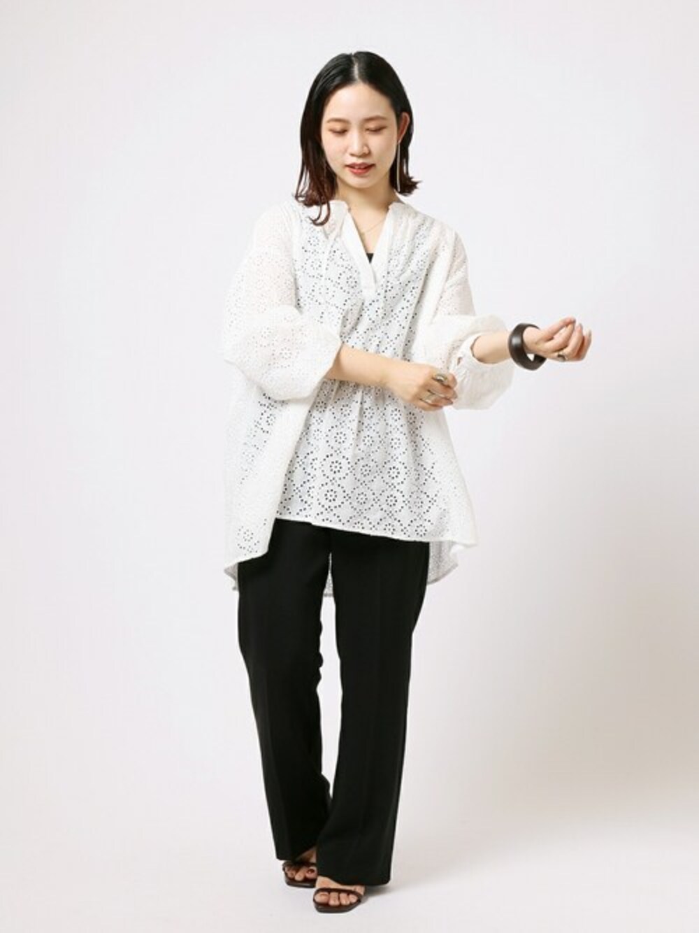 ホワイト系のシャツ/ブラウス、ブラック系のスラックスを着用したレディースの春コーディネートの1枚目の写真