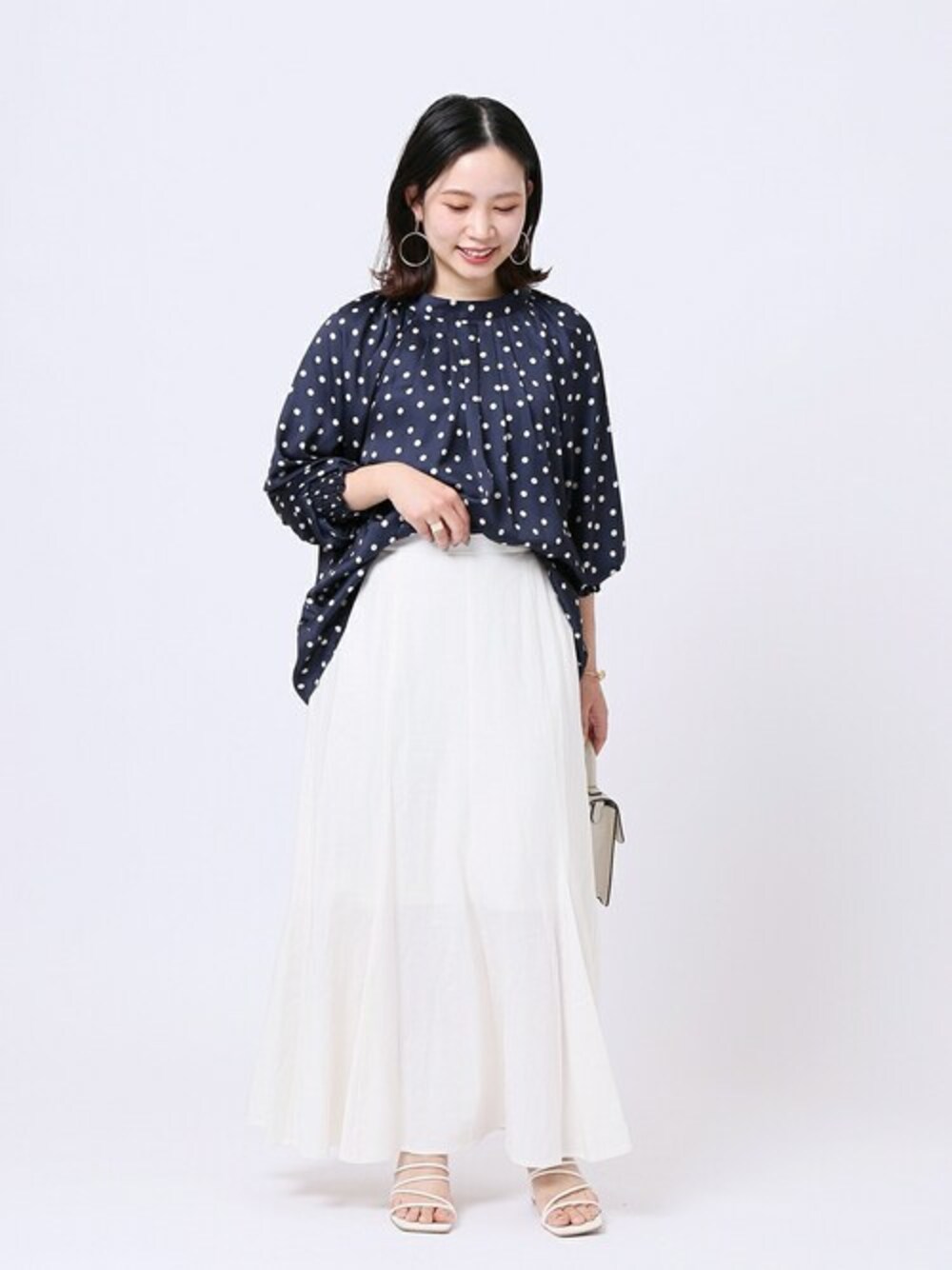 ブルー系のシャツ/ブラウス、ホワイト系のスカート、ホワイト系のショルダーバッグを着用したレディースの春コーディネートの1枚目の写真