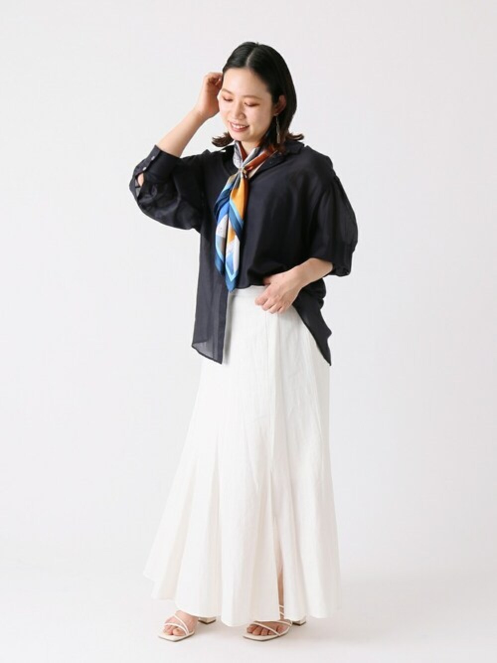 ブルー系のシャツ/ブラウス、ホワイト系のスカート、ブルー系のストール/ショールを着用したレディースの春コーディネートの1枚目の写真