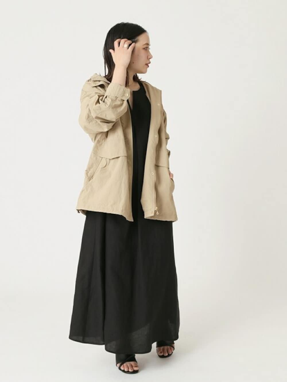 ベージュ系のブルゾン、ブラック系のワンピースを着用したレディースの春コーディネートの1枚目の写真