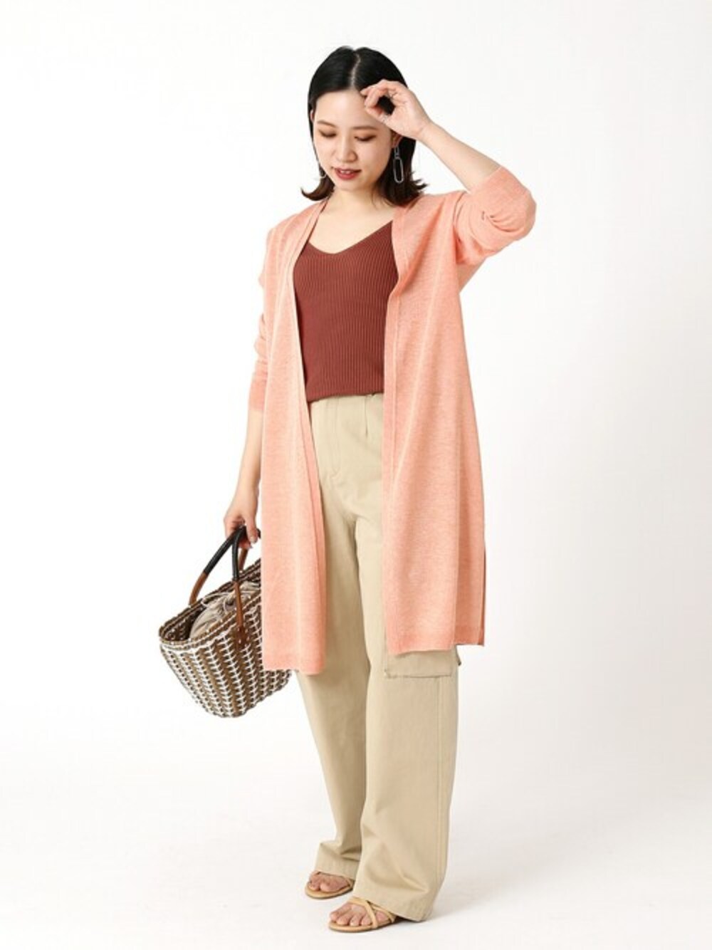 オレンジ系のカーディガン/ボレロ、ベージュ系のその他パンツを着用したレディースの春コーディネートの1枚目の写真