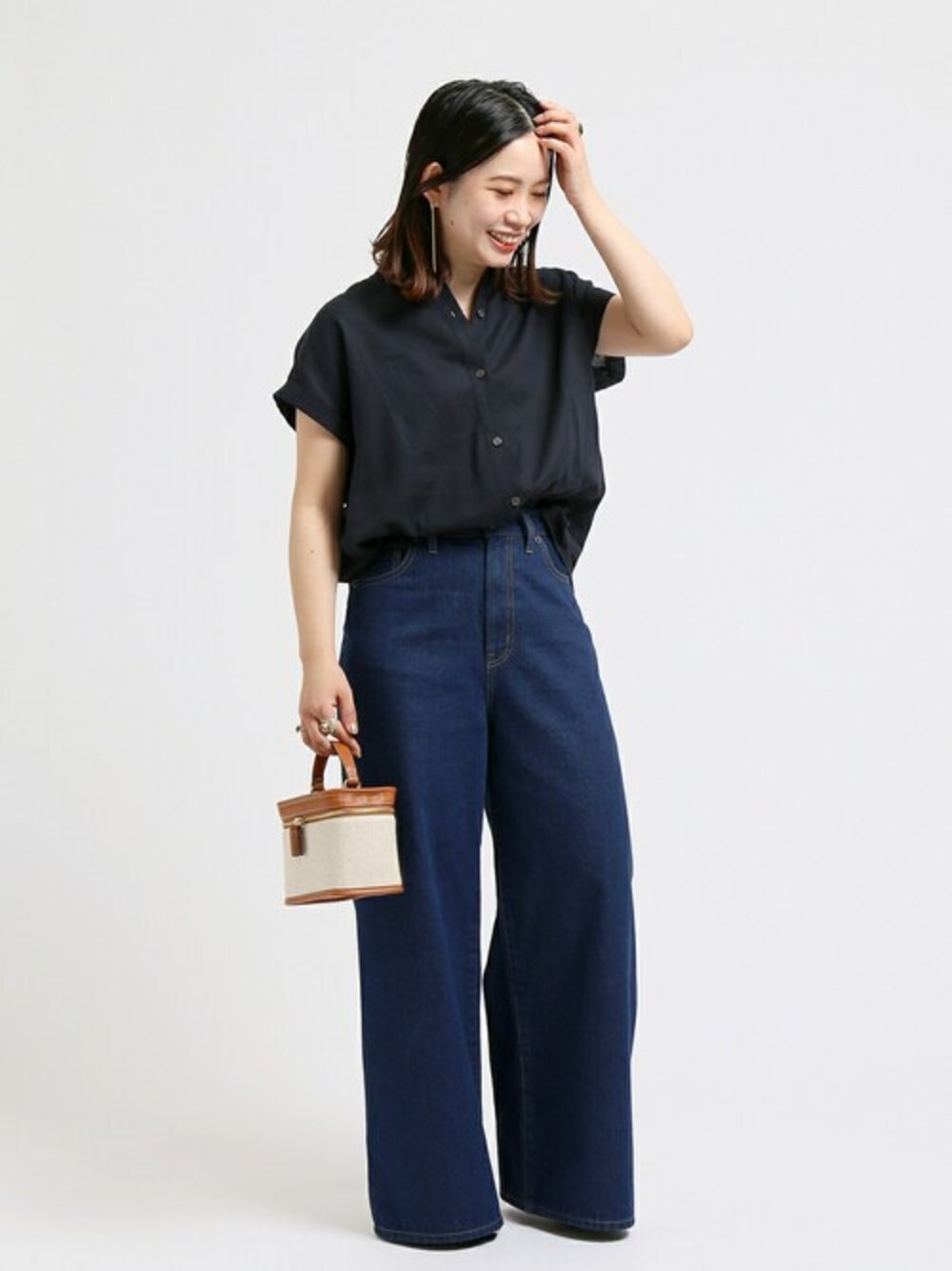 ブルー系のシャツ/ブラウス、ブラウン系のショルダーバッグ、ブルー系のデニムパンツを着用したレディースの春コーディネートの1枚目の写真