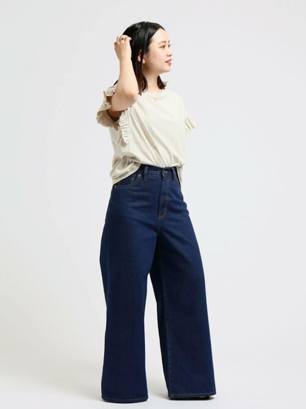 ベージュ系のシャツ/ブラウス、ブルー系のデニムパンツを着用したレディースの春コーディネートの1枚目の写真