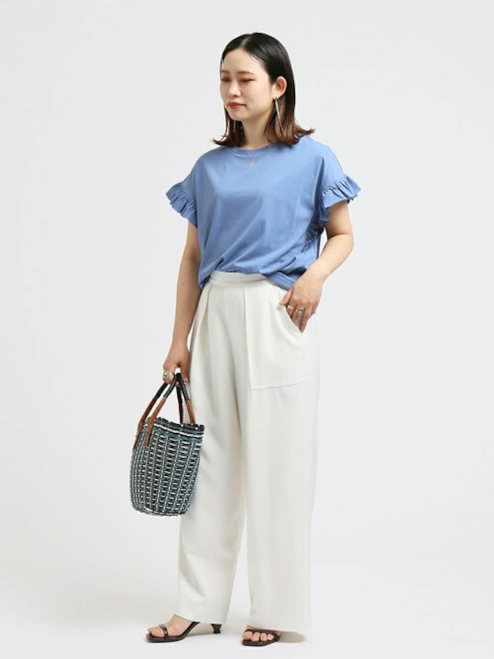 ブルー系のシャツ/ブラウス、ホワイト系のスラックスを着用したレディースの夏コーディネートの1枚目の写真