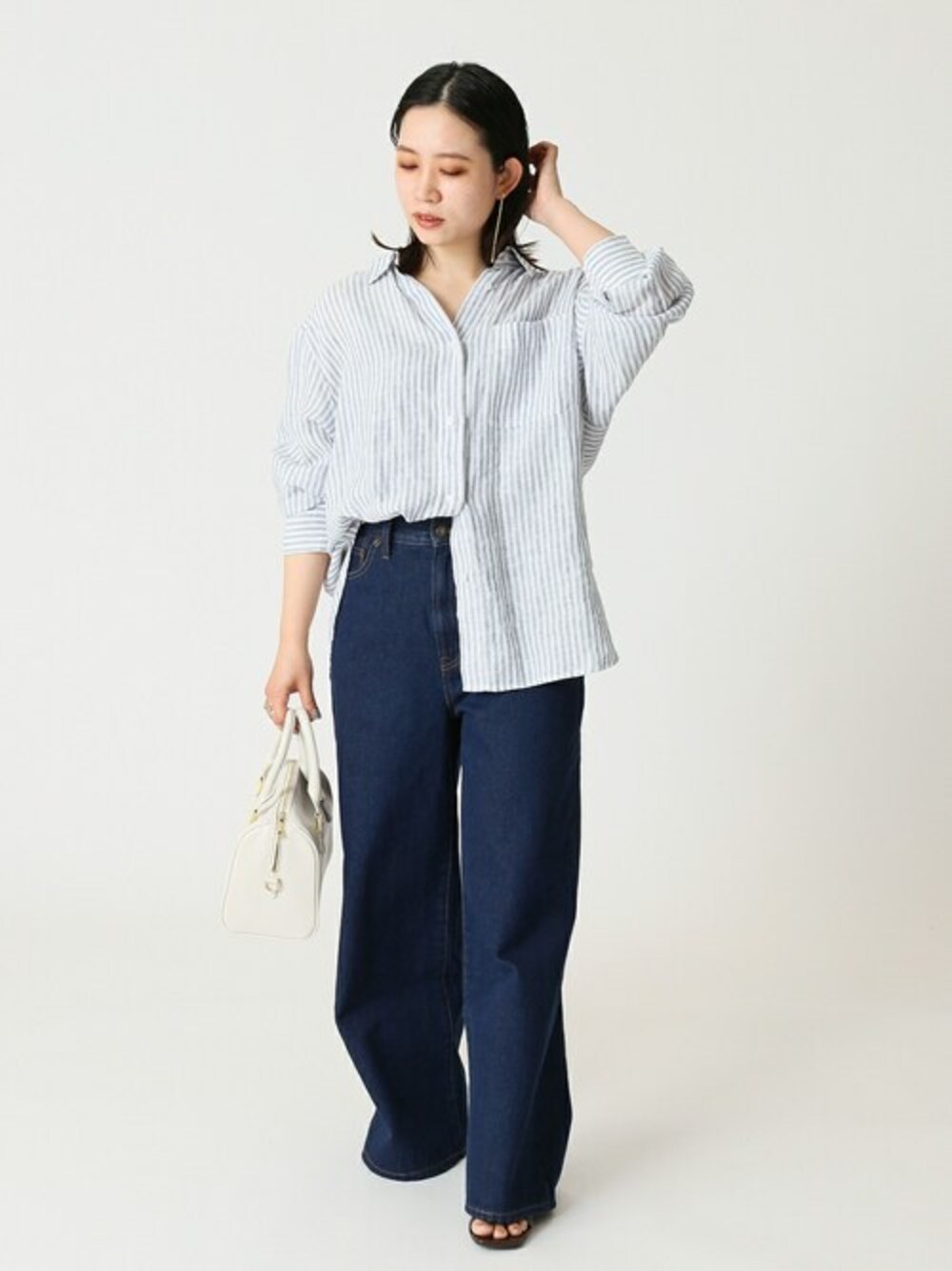 ブルー系のシャツ/ブラウス、ホワイト系のボストンバッグ、ブルー系のデニムパンツを着用したレディースの夏コーディネートの1枚目の写真