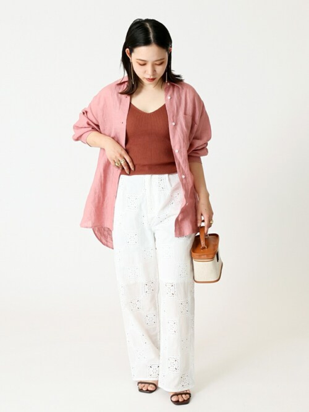 ピンク系のシャツ/ブラウス、ホワイト系のスラックス、ブラウン系のショルダーバッグを着用したレディースの夏コーディネートの1枚目の写真