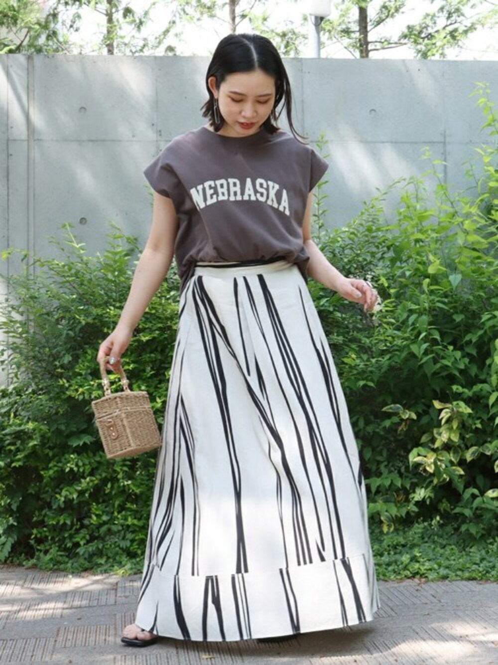 ブラック系のTシャツ/カットソー、ホワイト系のスカートを着用したレディースの夏コーディネートの1枚目の写真