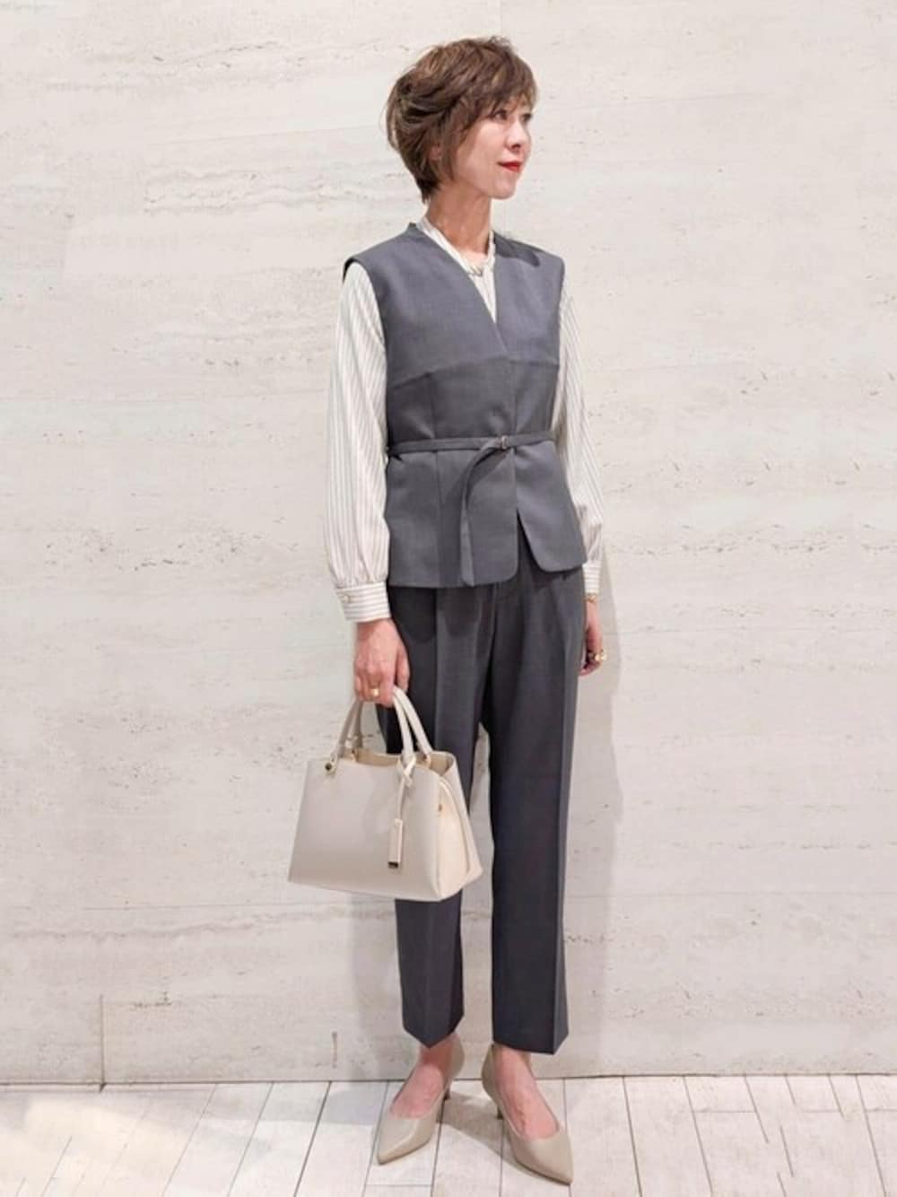 グレー系のベスト、ベージュ系のシャツ/ブラウス、グレー系のその他パンツを着用したレディースの春コーディネートの1枚目の写真