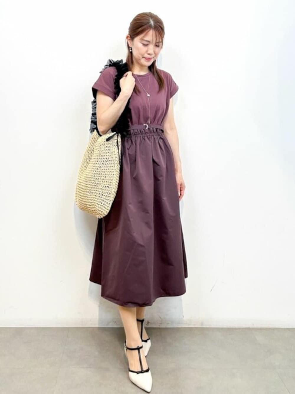 ブラウン系のワンピース、ベージュ系のトートバッグ、ホワイト系のパンプスを着用したレディースの夏コーディネートの1枚目の写真