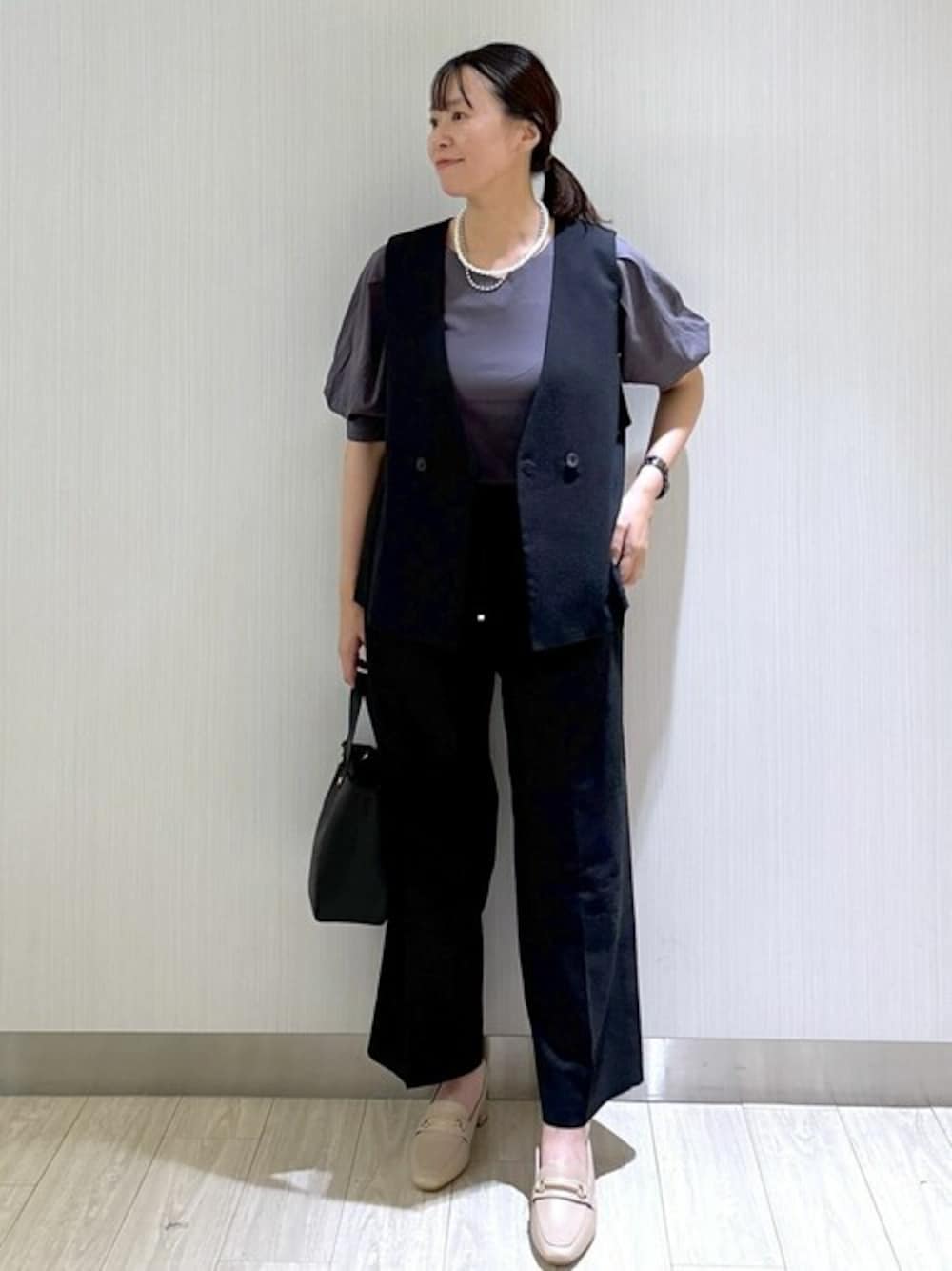 ブラック系のベスト、グレー系のTシャツ/カットソー、ブラック系のその他パンツを着用したレディースの秋コーディネートの1枚目の写真