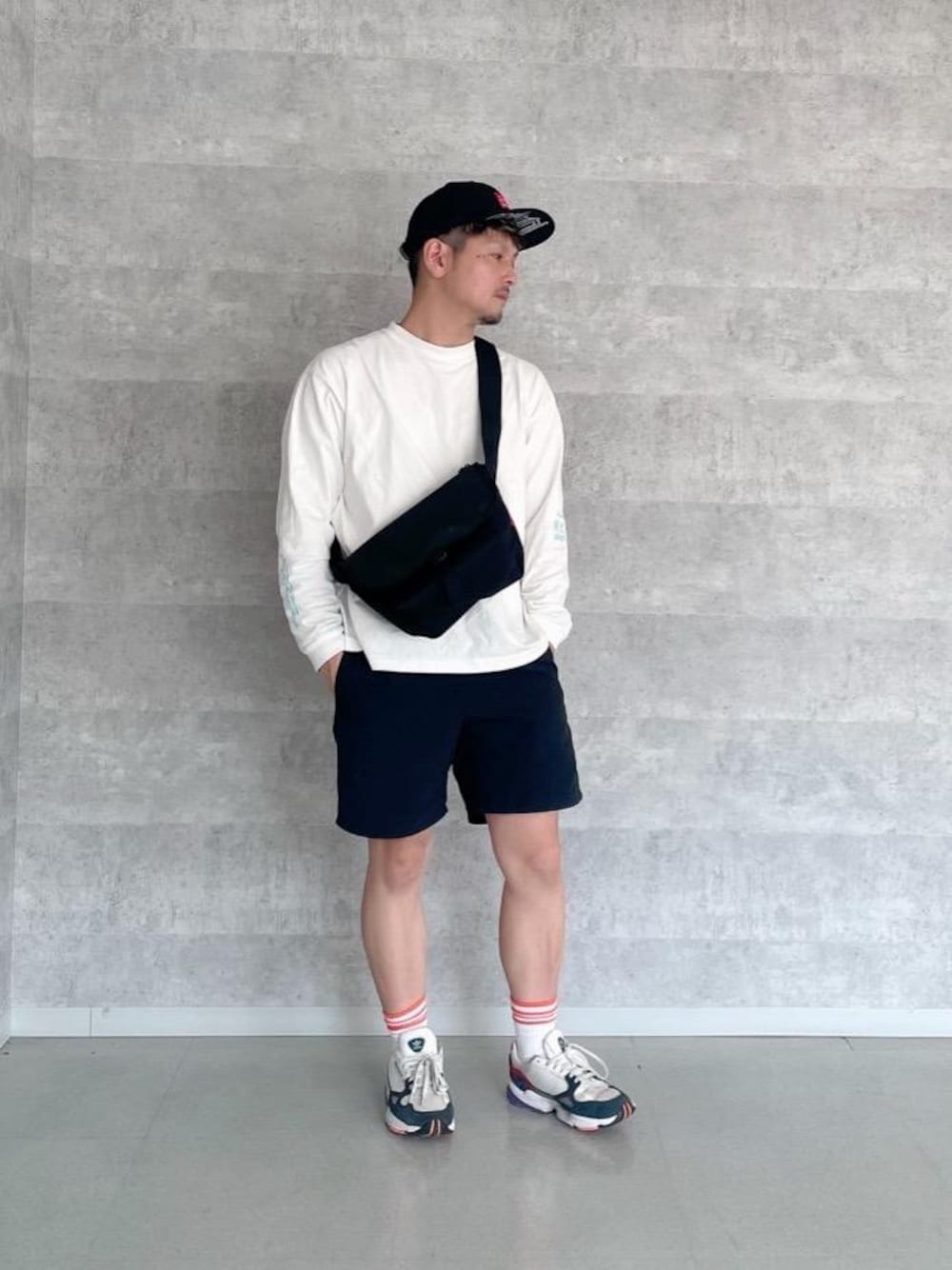 ブルー系のTシャツ/カットソー、ブラック系のメッセンジャーバッグを着用したメンズの夏コーディネートの1枚目の写真