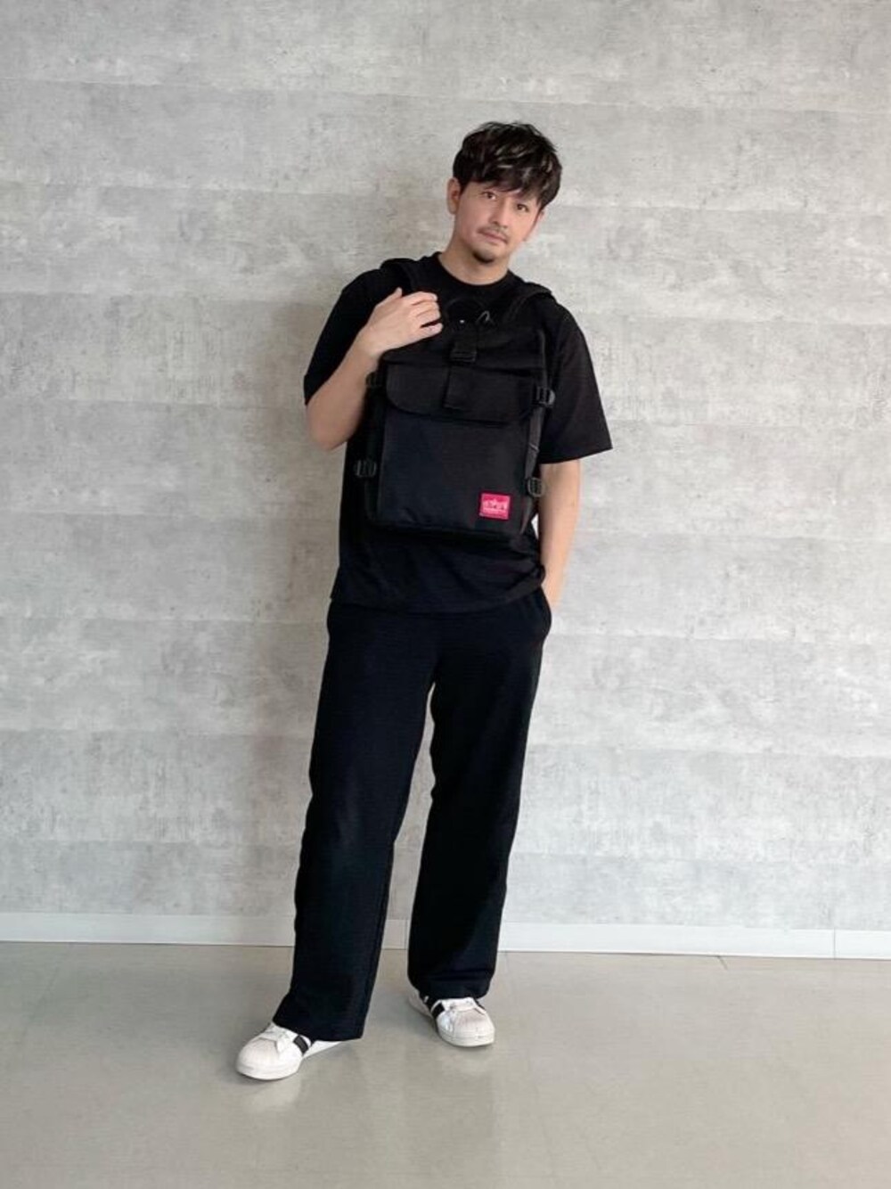 ブラック系のバックパック/リュック、ブラック系のTシャツ/カットソーを着用したメンズの夏コーディネートの1枚目の写真