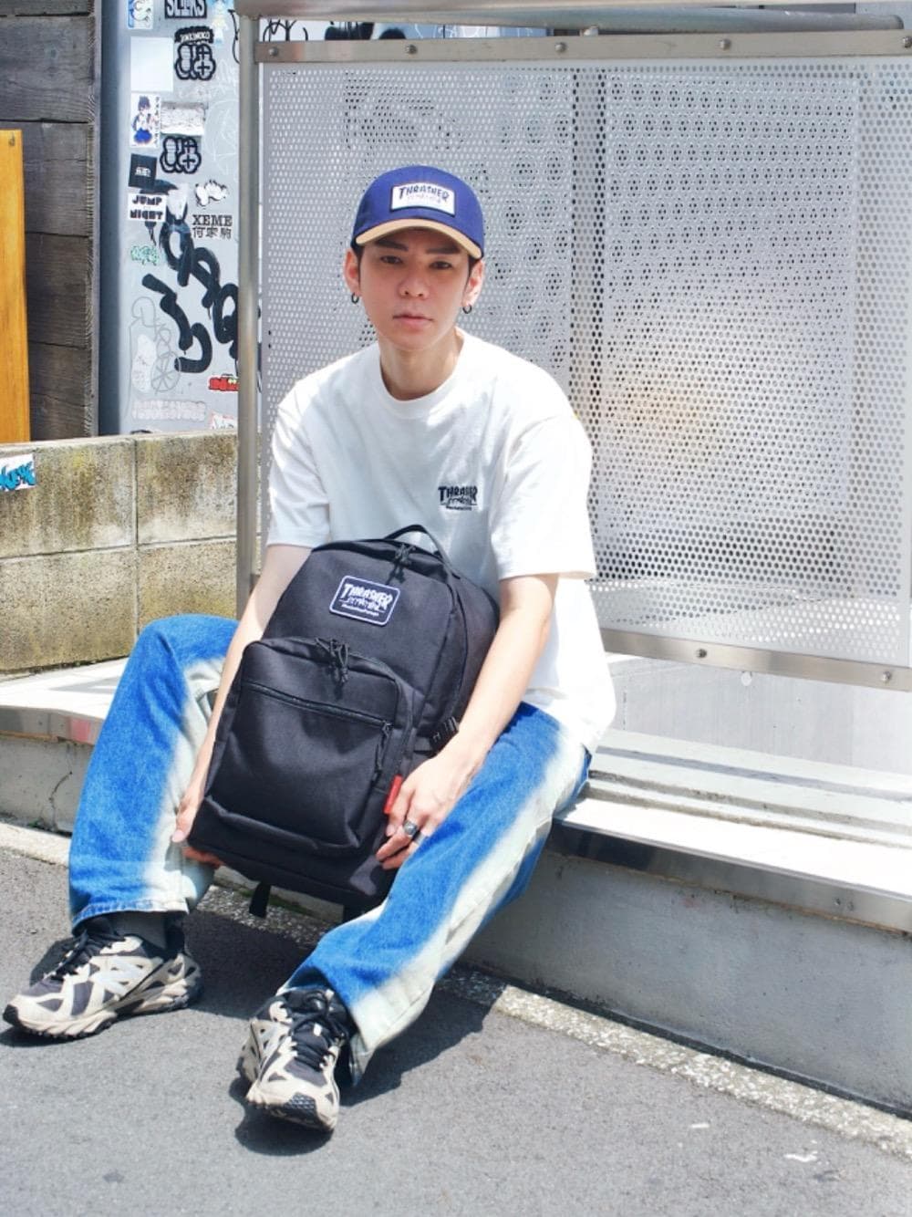 ブラック系のバックパック/リュック、ホワイト系のTシャツ/カットソー、ブルー系のキャップを着用したメンズの夏コーディネートの1枚目の写真