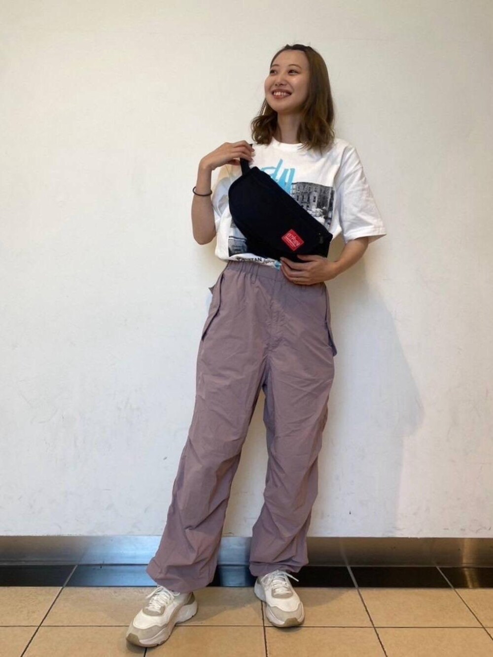 ブラック系のボディバッグ/ウエストポーチ、ホワイト系のTシャツ/カットソーを着用したレディースの夏コーディネートの1枚目の写真