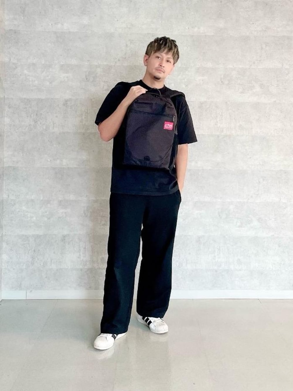 ブラック系のバックパック/リュック、ブラック系のTシャツ/カットソーを着用したメンズの夏コーディネートの1枚目の写真