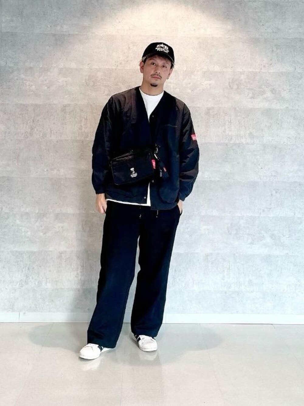 ブラック系のショルダーバッグ、ブラック系のキャップを着用したメンズの秋コーディネートの1枚目の写真