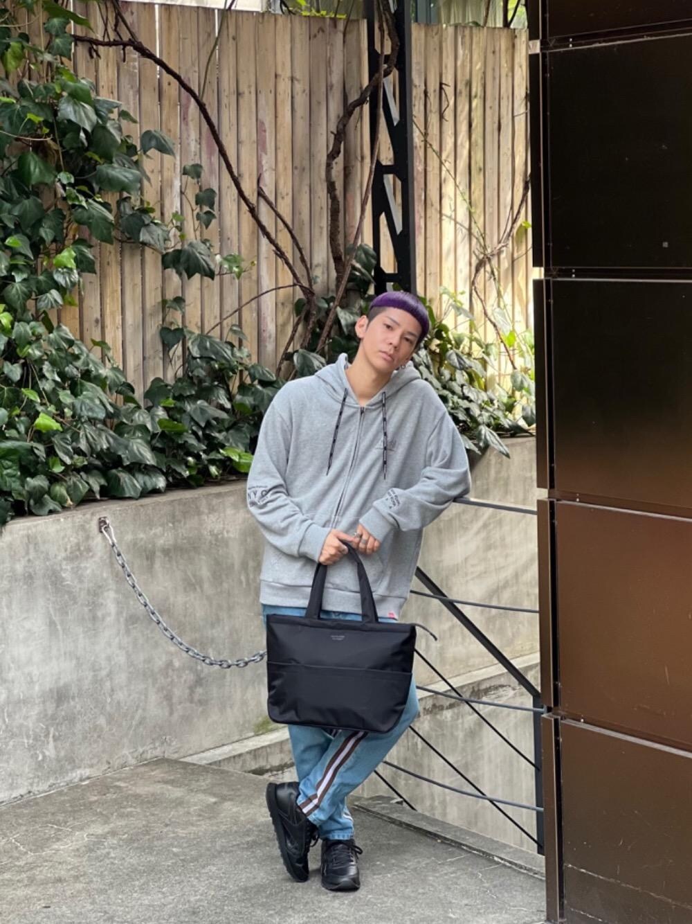 ブラック系のトートバッグ、グレー系のパーカーを着用したメンズの秋コーディネートの1枚目の写真