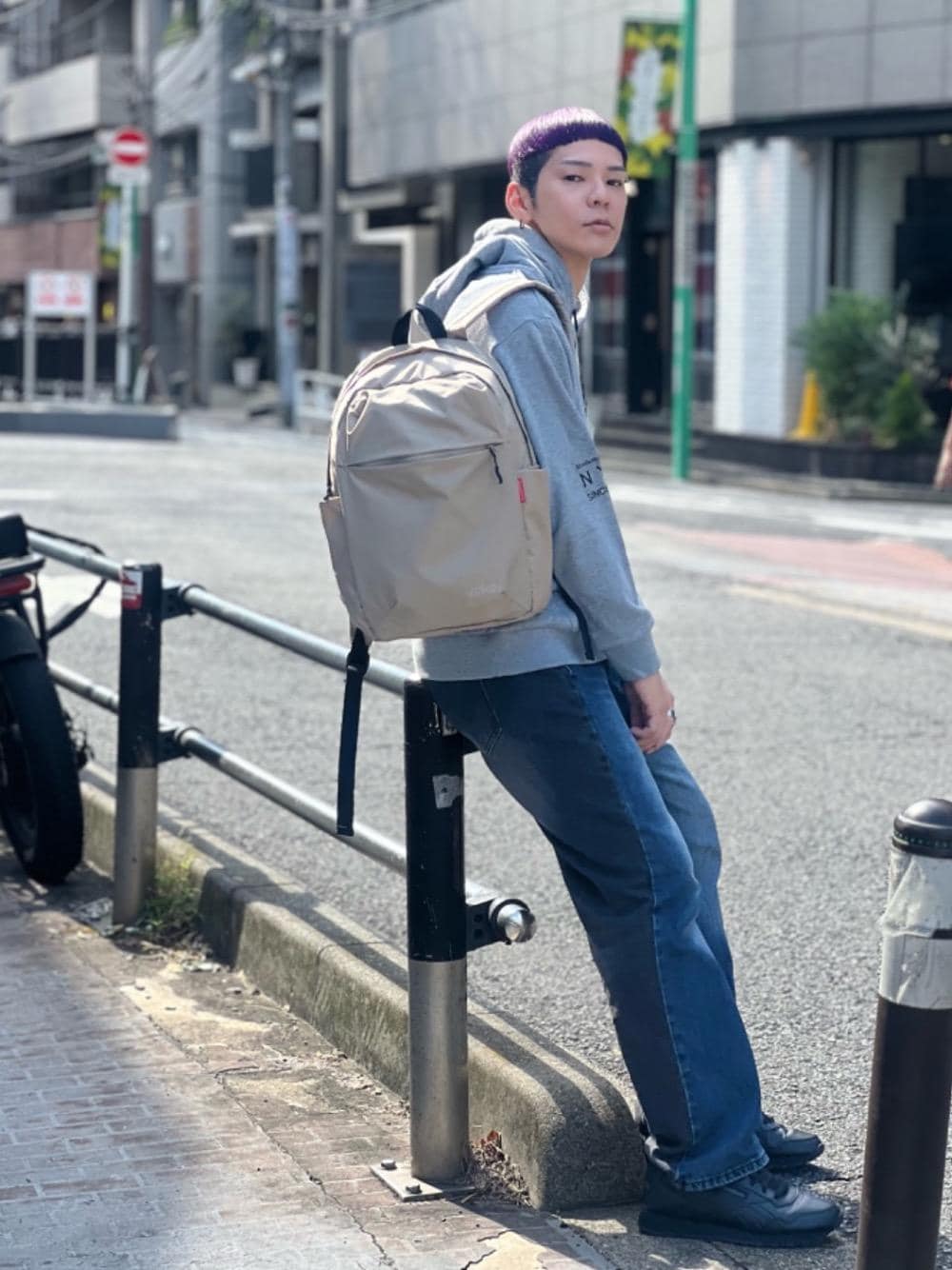 グレー系のパーカー、ベージュ系のバックパック/リュックを着用したメンズの秋コーディネートの1枚目の写真