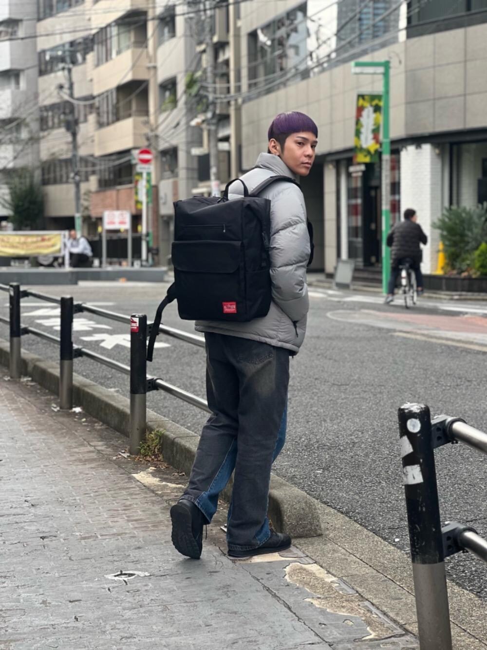 ブラック系のバックパック/リュック、グレー系のダウンジャケット/コートを着用したメンズの秋コーディネートの1枚目の写真