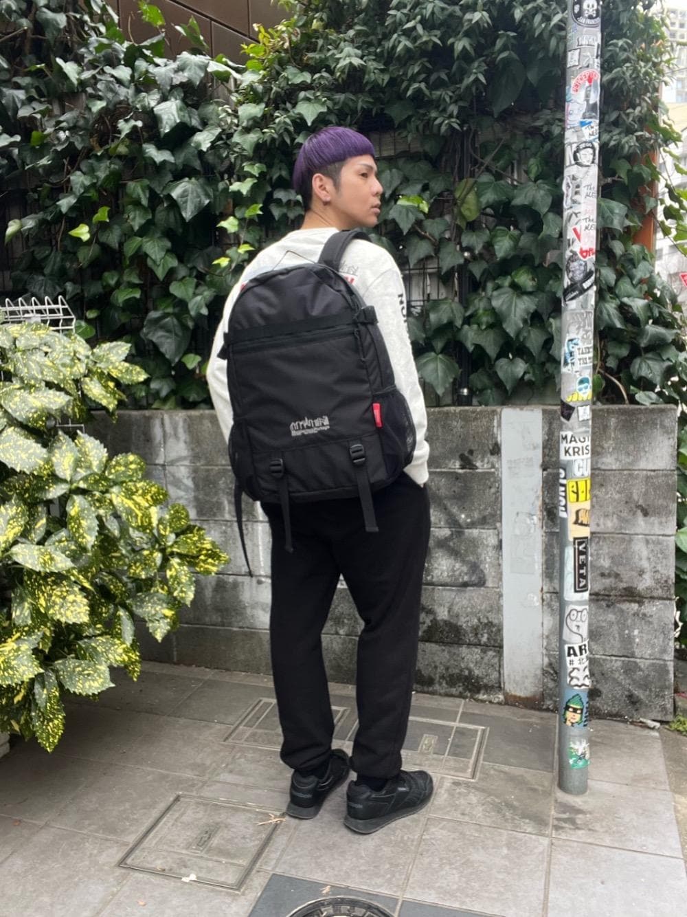 ブラック系のバックパック/リュック、ベージュ系のTシャツ/カットソーを着用したメンズの春コーディネートの1枚目の写真