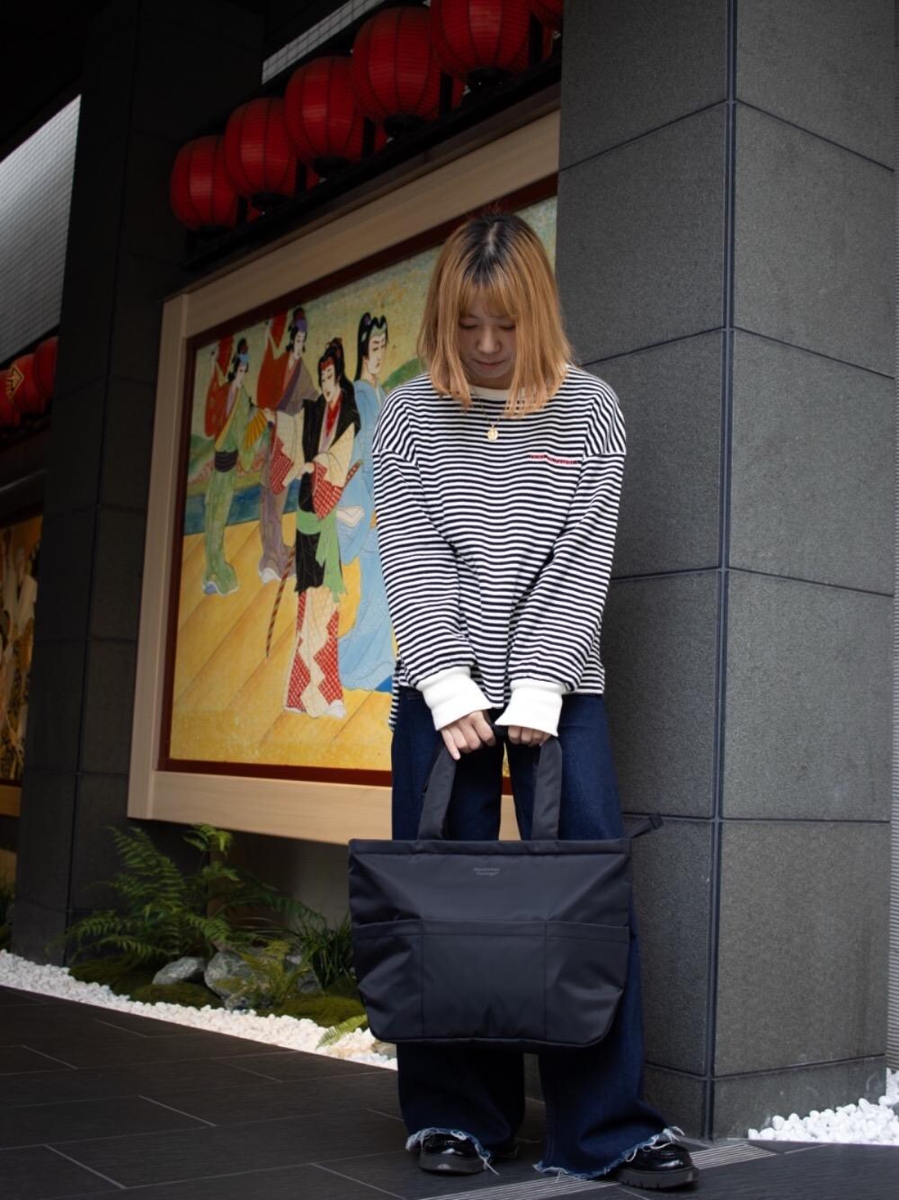 ブラック系のトートバッグを着用したレディースの春コーディネートの1枚目の写真
