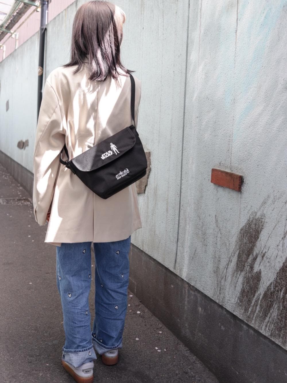 ブラック系のメッセンジャーバッグを着用したレディースの春コーディネートの1枚目の写真