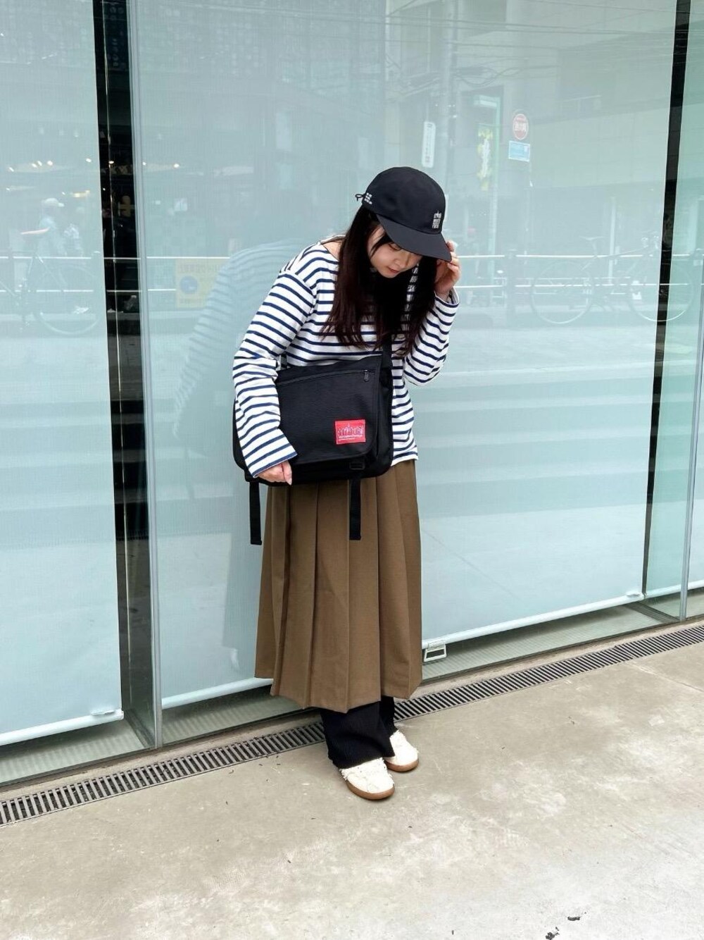 ブラック系のショルダーバッグ、ブラック系のキャップを着用したレディースの春コーディネートの1枚目の写真