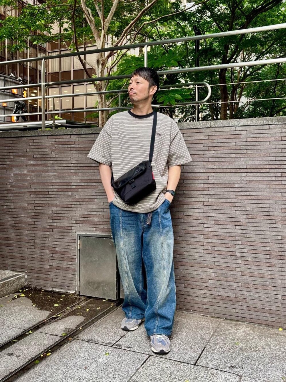 ブラック系のメッセンジャーバッグを着用したメンズの春コーディネートの1枚目の写真