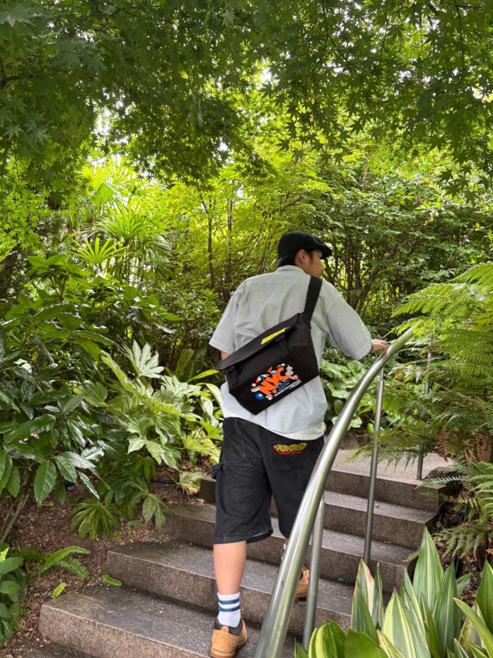 ブラック系のメッセンジャーバッグを着用したメンズの夏コーディネートの1枚目の写真