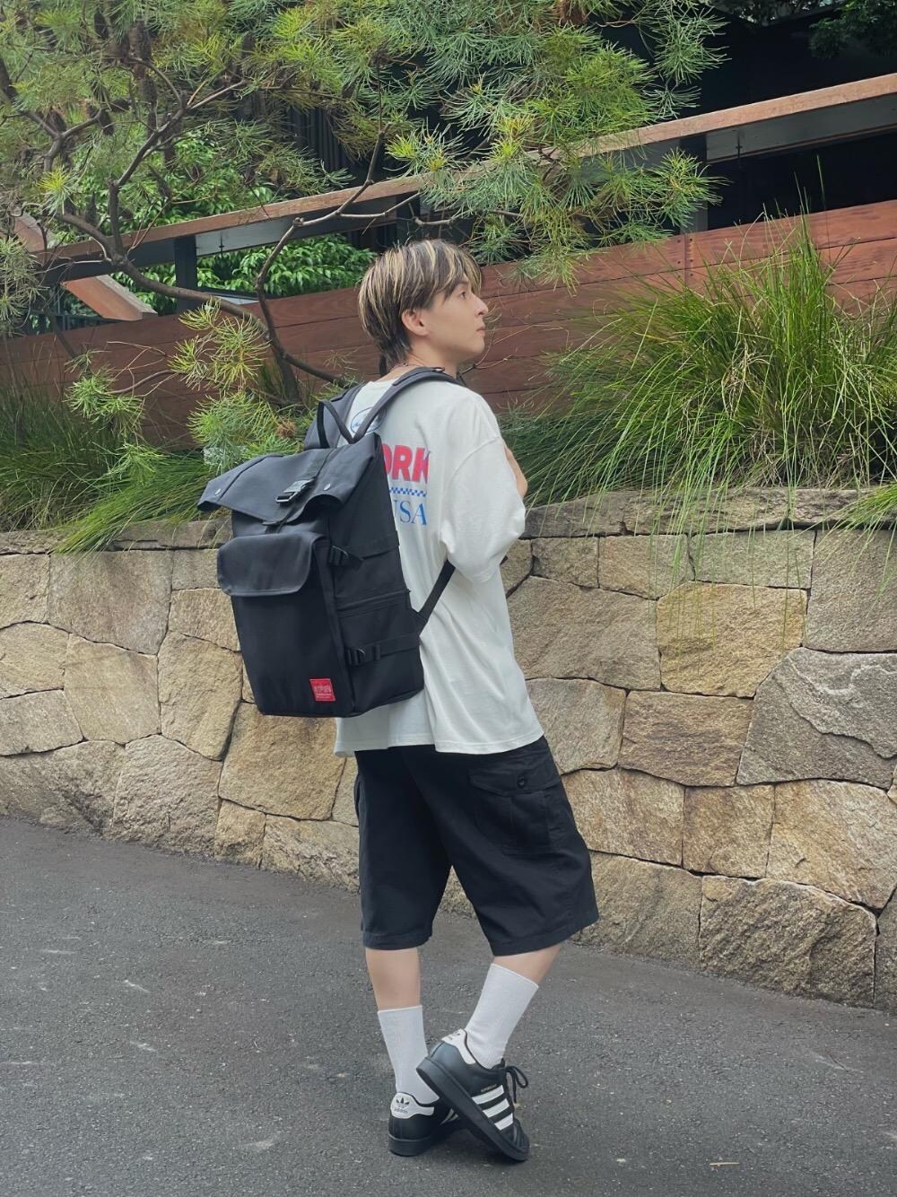 ブラック系のバックパック/リュック、ホワイト系のTシャツ/カットソーを着用したメンズの夏コーディネートの1枚目の写真