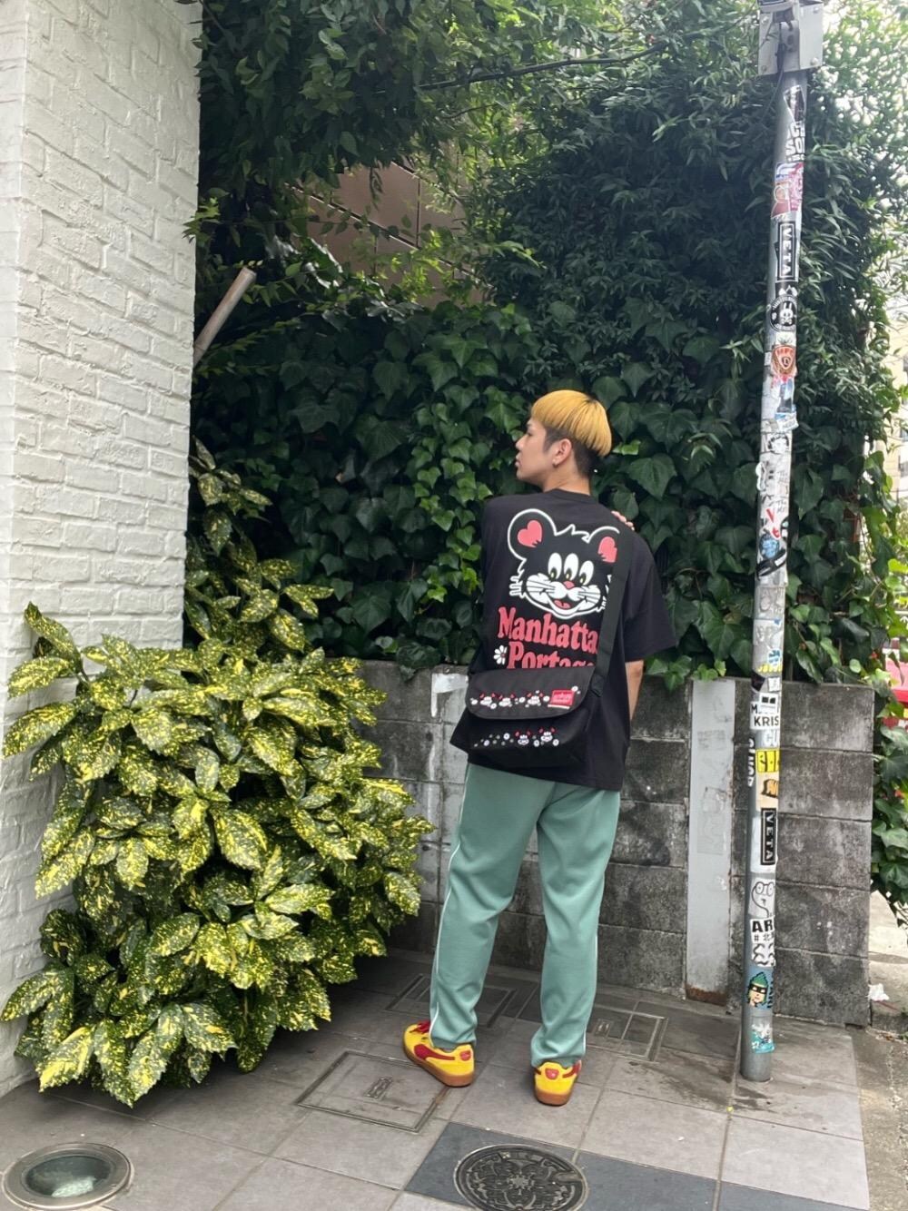 ブラック系のメッセンジャーバッグ、ブラック系のTシャツ/カットソーを着用したメンズの夏コーディネートの1枚目の写真