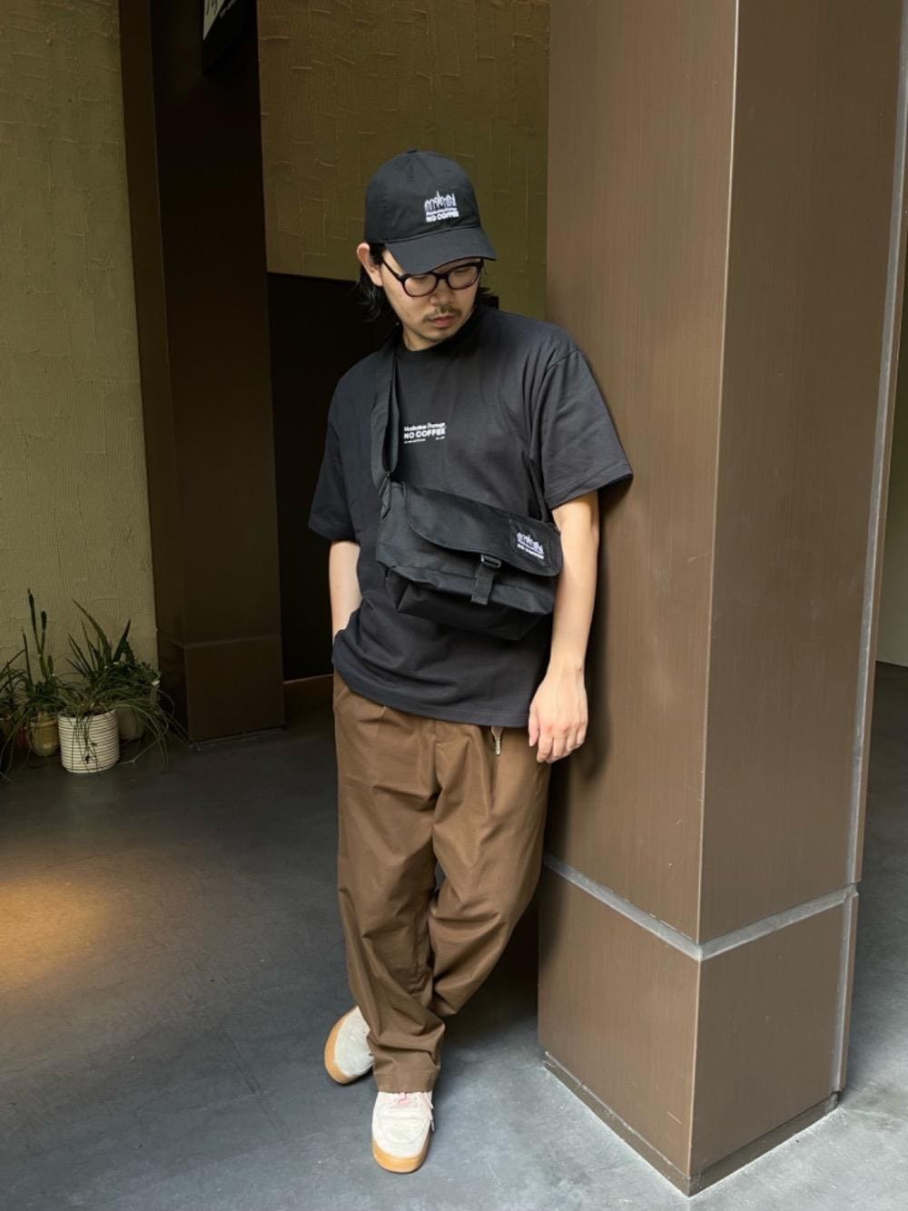 ブラック系のメッセンジャーバッグ、ブラック系のキャップを着用したメンズの秋コーディネートの1枚目の写真