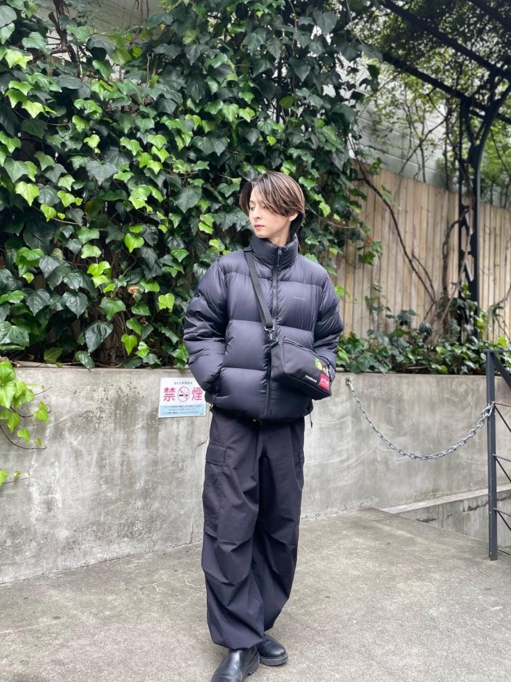 ブラック系のダウンジャケット/コート、ブラック系のショルダーバッグを着用したメンズの秋コーディネートの1枚目の写真