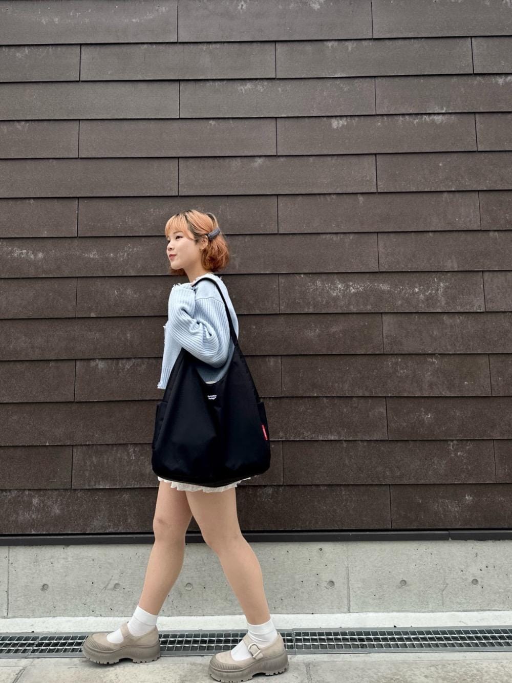 ブラック系のトートバッグを着用したレディースの春コーディネートの1枚目の写真