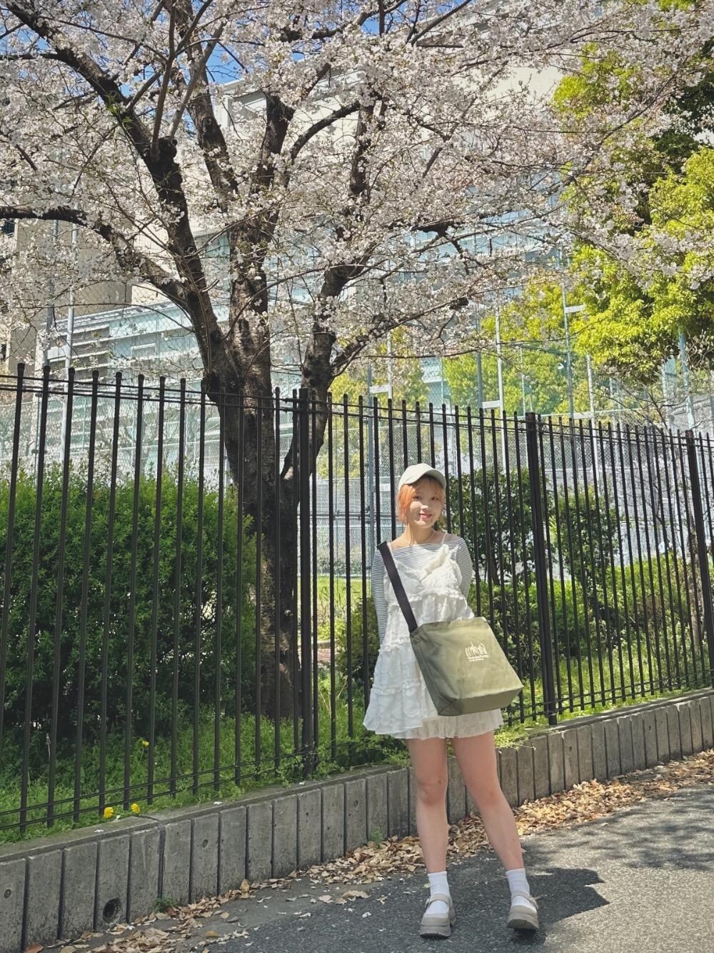 グリーン系のショルダーバッグを着用したレディースの春コーディネートの1枚目の写真