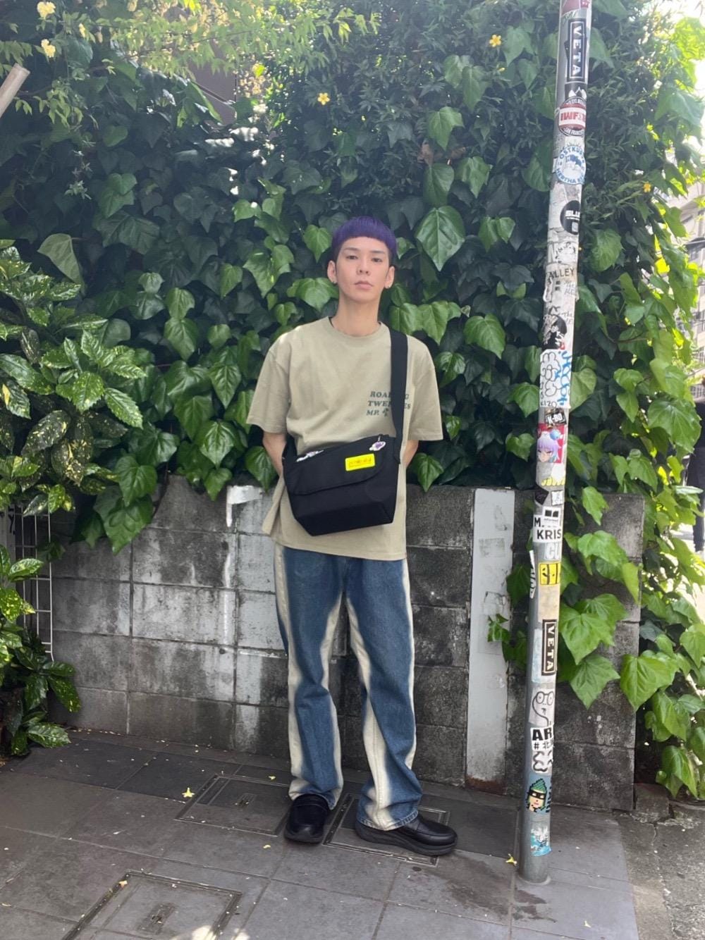 グリーン系のTシャツ/カットソー、ブラック系のメッセンジャーバッグを着用したメンズの春コーディネートの1枚目の写真