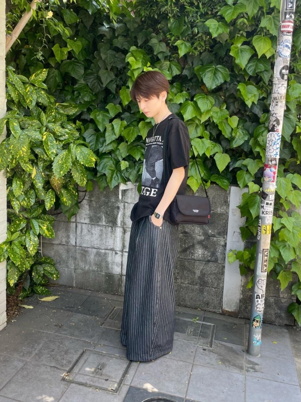 ブラック系のショルダーバッグ、ブラック系のTシャツ/カットソーを着用したメンズの春コーディネートの1枚目の写真