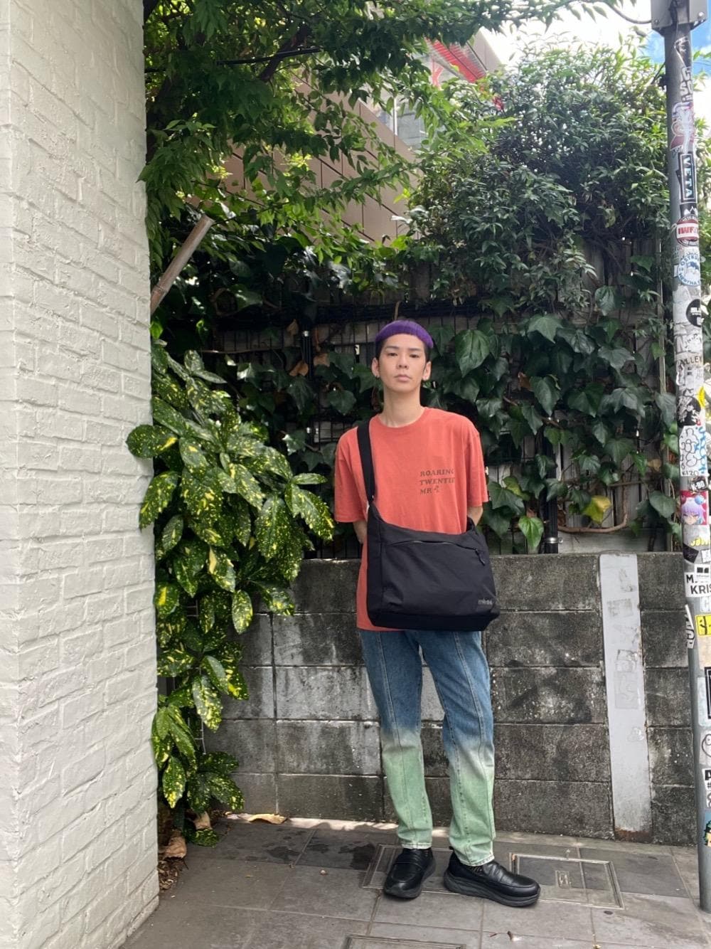 ブラック系のショルダーバッグ、オレンジ系のTシャツ/カットソーを着用したメンズの春コーディネートの1枚目の写真