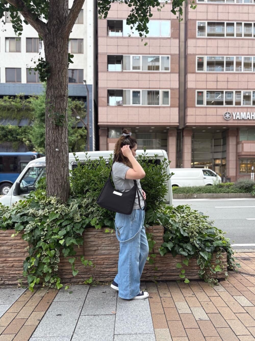 ブラック系のショルダーバッグを着用したレディースの夏コーディネートの1枚目の写真